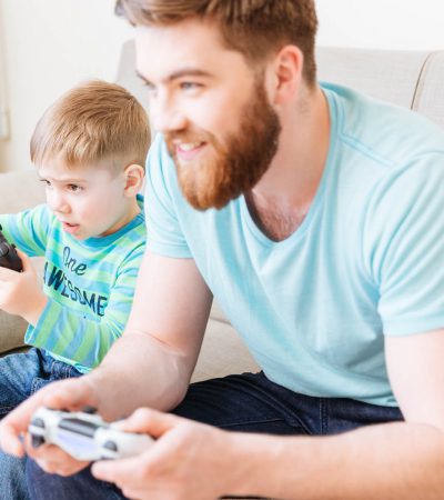dad and son play some videogames at home