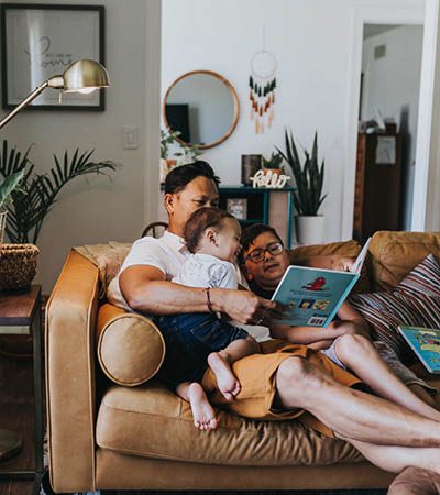 relaxed dad reads kids story on sofa