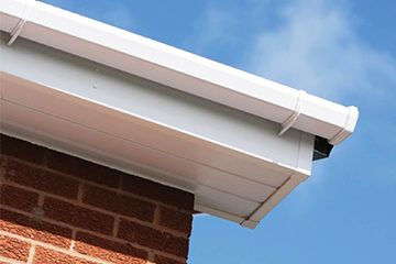 white soffits of a roofline system on a red brick house